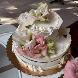 HeritageBakes3 Two-tiered wedding cake with elaborate flower decorations.