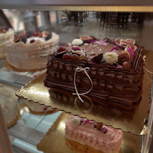 Two elaborately decorated cakes in a glass case.